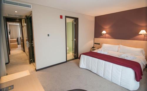 a hotel room with a large bed and a bathroom at Salto Hotel y Casino in Salto