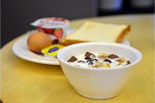 a bowl of cereal and a plate of bread and eggs at Browndot Business Seomyeon in Busan
