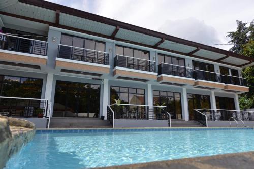 a hotel with a swimming pool in front of a building at Hotel Gabriella in Tagbilaran City