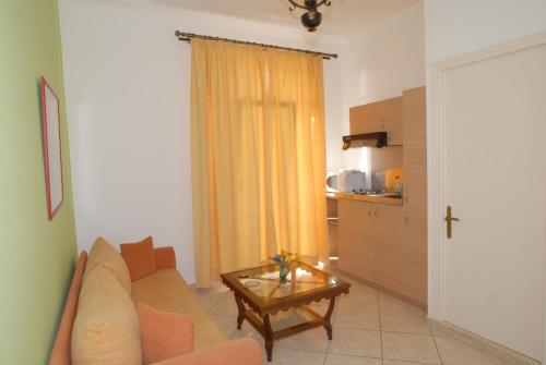 Molyvos Queen Apartments في ميثيمنا: غرفة معيشة مع أريكة وطاولة