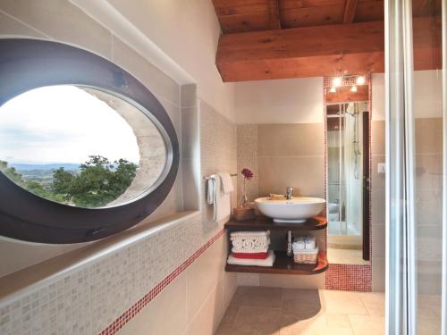a bathroom with a round window and a sink at Agriturismo Il Vecchio Mandorlo in Perugia