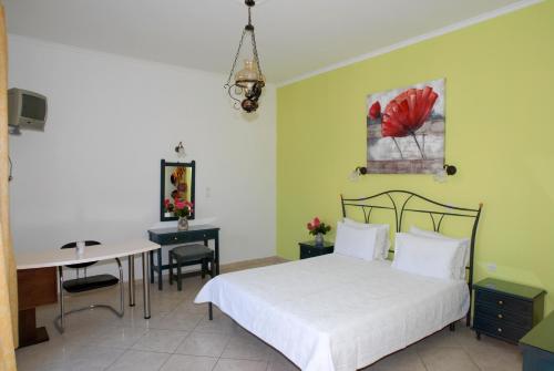 ミティムナにあるMolyvos Queen Apartmentsのベッドとテーブルと机のある寝室