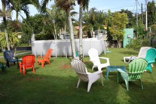 a group of colorful chairs sitting in the grass at Little Italy B&B in Boquerón