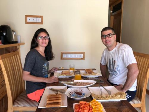 a man and a woman sitting at a table with food at Mariana Maldives in Gaafaru
