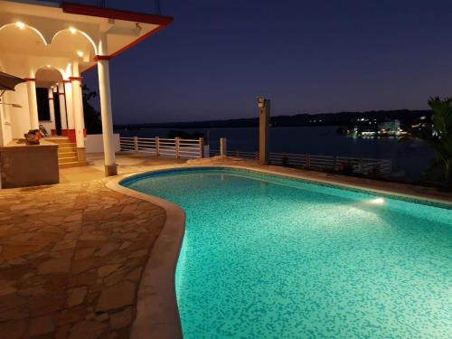 a swimming pool with a view of the water at night at APARTHOTEL VISTA LAGO in Flores