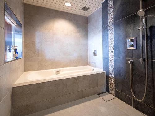y baño con bañera y ducha. en HOTEL MYSTAYS PREMIER Narita en Narita