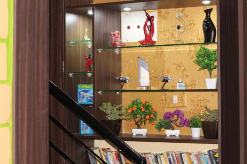 una estantería de libros con macetas y libros en Arra Transit Bengaluru International Airport Hotel en Yelahanka