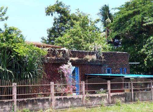 a house with a surfboard in front of a fence at Rumah Batu in Buleleng
