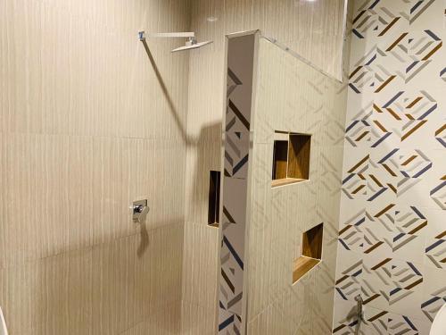 a shower with a glass door in a bathroom at โรงแรมมาลินี in Surin