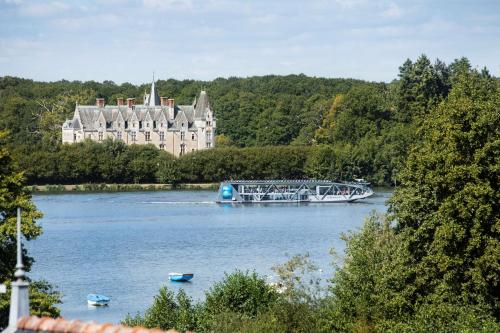 a large castle on a river with a bridge and boats at Best Western Plus Hotel De La Regate-Erdre in Nantes
