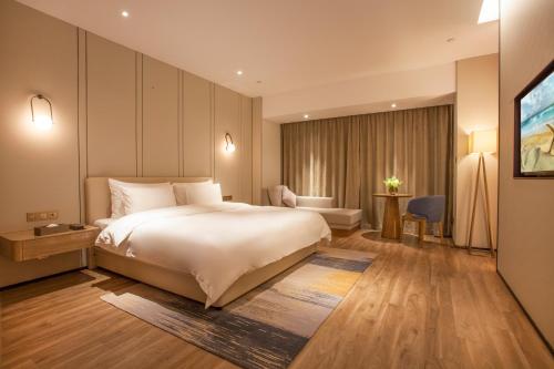 a hotel room with a bed and a television at Nanan Ao Sheng Yi Hao Hotel in Quanzhou