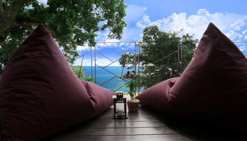 two large pink pillows on a deck with a view of the ocean at Pahili Pool Villas Koh Tao - SHA Plus in Koh Tao