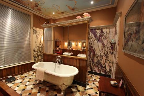a bathroom with a bath tub and a sink at B&B De Lachende Engel in Mechelen