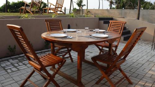a wooden table and chairs on a patio at Ayana Beach in Ja-Ela