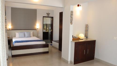 a bedroom with a bed and a vanity and a mirror at Ayana Beach in Ja-Ela