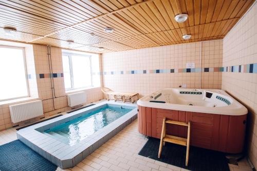 a large bathroom with a tub and a chair in it at Evropa Hotel in Magnitogorsk