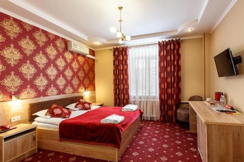 Habitación de hotel con cama con manta roja en Renion Zyliha Hotel, en Almaty