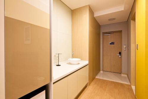 a bathroom with a sink and a mirror at Sono Calm Geoje in Geoje 