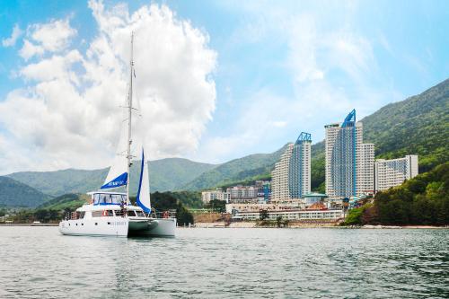 a sailboat on the water in front of a city at Sono Calm Geoje in Geoje 