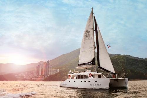 a sailboat in the water with a city in the background at Sono Calm Geoje in Geoje 