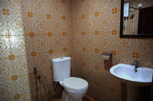 uma casa de banho com um WC e um lavatório em 1 Baron Motel em Kuah