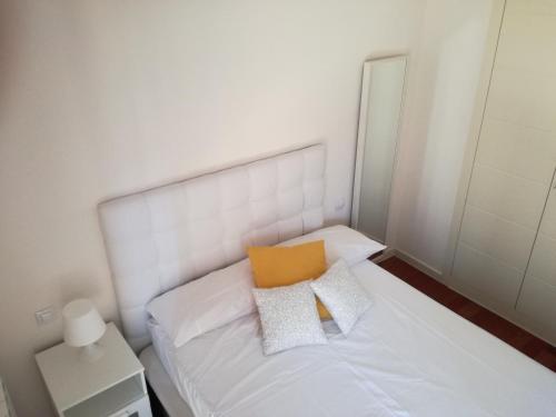 サビニャニゴにあるCómodo apart. en las Margas,Sabiñanigoの小さなベッドルーム(白いベッド、黄色い枕付)