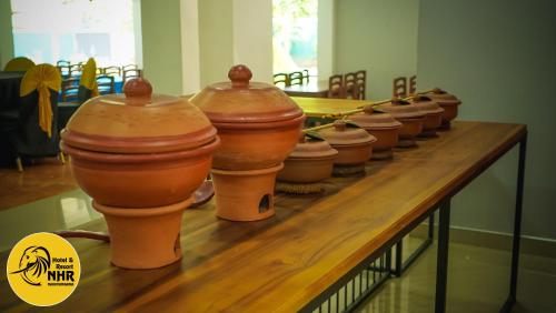 a row of clay pots sitting on a table at National Holiday Resort in Mahiyangana