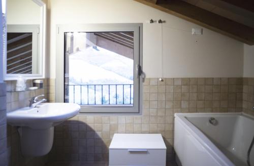 a bathroom with a sink and a toilet and a window at Agriturismo Ben Ti Voglio in Bologna