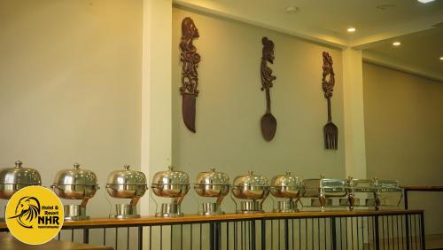 a row of glass bowls and spoons on a shelf at National Holiday Resort in Mahiyangana