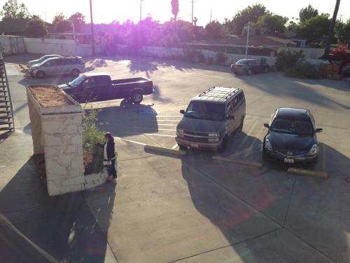 un hombre parado en un estacionamiento con dos coches en Economy Inn, en Sun Valley