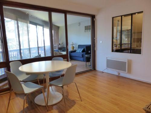 uma sala de jantar e sala de estar com mesa e cadeiras em Appartement 2 personnes vue sur le port #0278 em Soorts-Hossegor