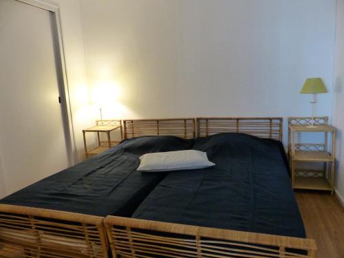 uma cama grande com um edredão preto num quarto em Appartement 2 personnes vue sur le port #0278 em Soorts-Hossegor
