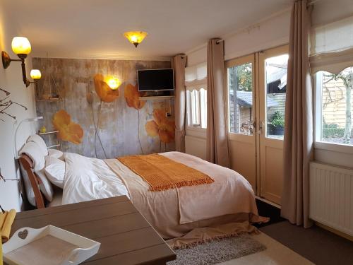 ein Schlafzimmer mit einem Bett und einem Tisch darin in der Unterkunft B&B Usselo Klein, fijn en uniek! in Enschede
