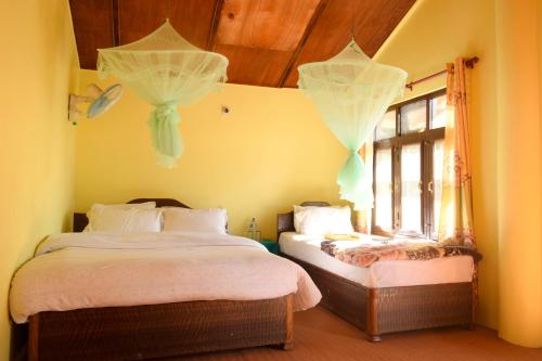 BhurkīāにあるNature Safari Resortのベッドルーム1室(ベッド2台、窓付)
