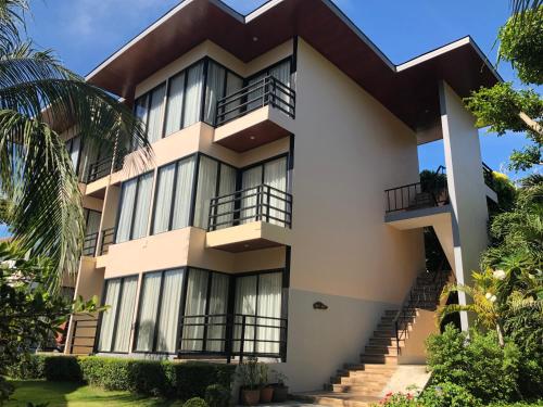 a large white building with balconies and trees at Phi Phi Villa Resort in Phi Phi Don