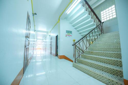 a staircase in a building with a stair case at Nadpob Mansion in Surat Thani