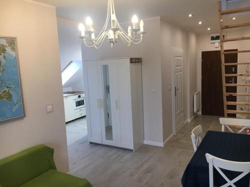 a living room with a table and a chandelier at Apartamenty Baltyk in Karwia