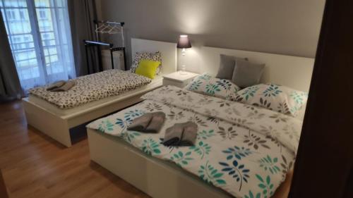 two beds with slippers on them in a bedroom at Apartman 404 in Jáchymov