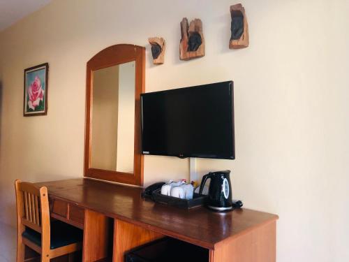 a desk with a television and a mirror on a wall at Phi Phi Villa Resort-SHA Extra Plus in Phi Phi Islands