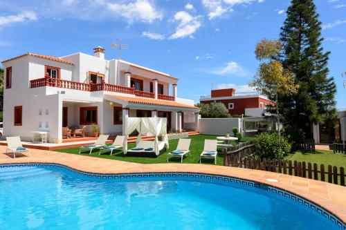 a villa with a swimming pool in front of a house at Sa Carroca Villa in Sant Josep de Sa Talaia