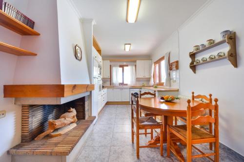 a kitchen and dining room with a fireplace at Sa Carroca Villa in Sant Josep de Sa Talaia