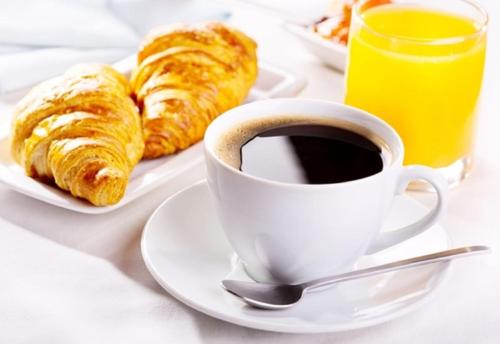 a cup of coffee and croissants on a table at Hotel El Biar in Alger