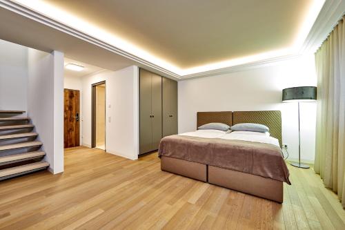 a bedroom with a bed and a staircase at City Suites Murnau in Murnau am Staffelsee