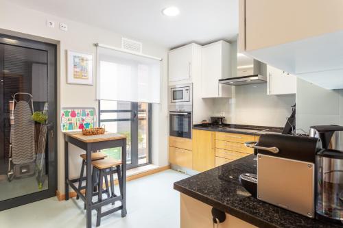 a kitchen with white cabinets and a counter top at O SITIO CERTO in Olhão