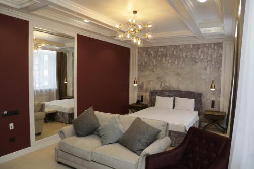 a bedroom with a couch and a bed and a chandelier at TELEGRAPH INN in Petropavlovsk