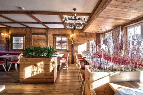 ein Restaurant mit Tischen, Stühlen und einem Kronleuchter in der Unterkunft Hotel Sonneneck Titisee -Adults Only- in Titisee-Neustadt