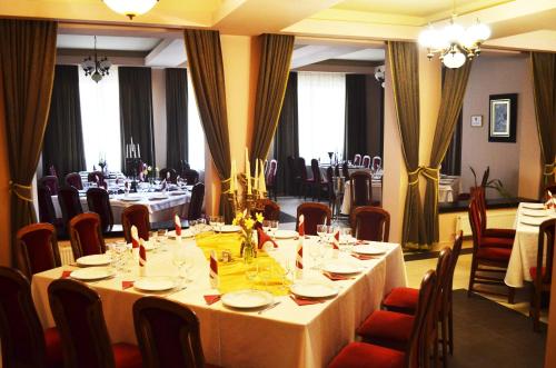 a dining room with a long table and chairs at Pensiunea Magura in Baia Mare