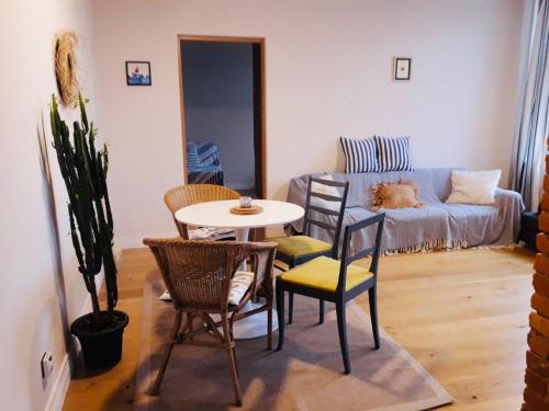 uma sala de estar com uma mesa e cadeiras e um sofá em Stylish apartment with sauna em Kuressaare