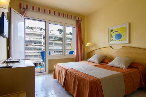 a hotel room with a bed and a large window at Florida in Tossa de Mar