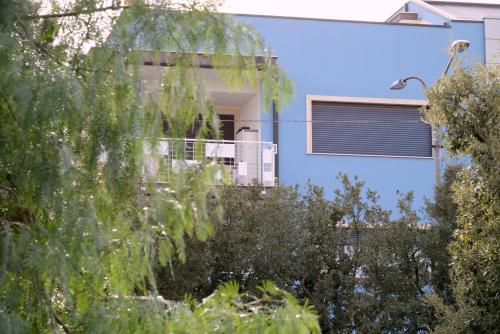 a blue house with a balcony and trees at "La casa di Mariagrazia" Appartamento 4 locali in Sammichele di Bari